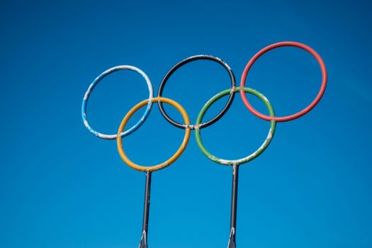 Smartphone met olympische spelen programma vandaag en uitslagen, met sportkijkers op terras in Tiel